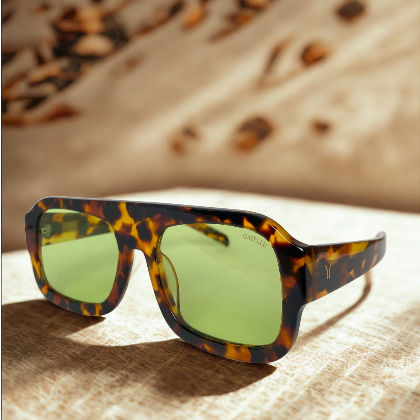 Vista lateral de gafas Gazelle Indómita Sol con fondo con diseño versátil y lentes verdes en Calvià