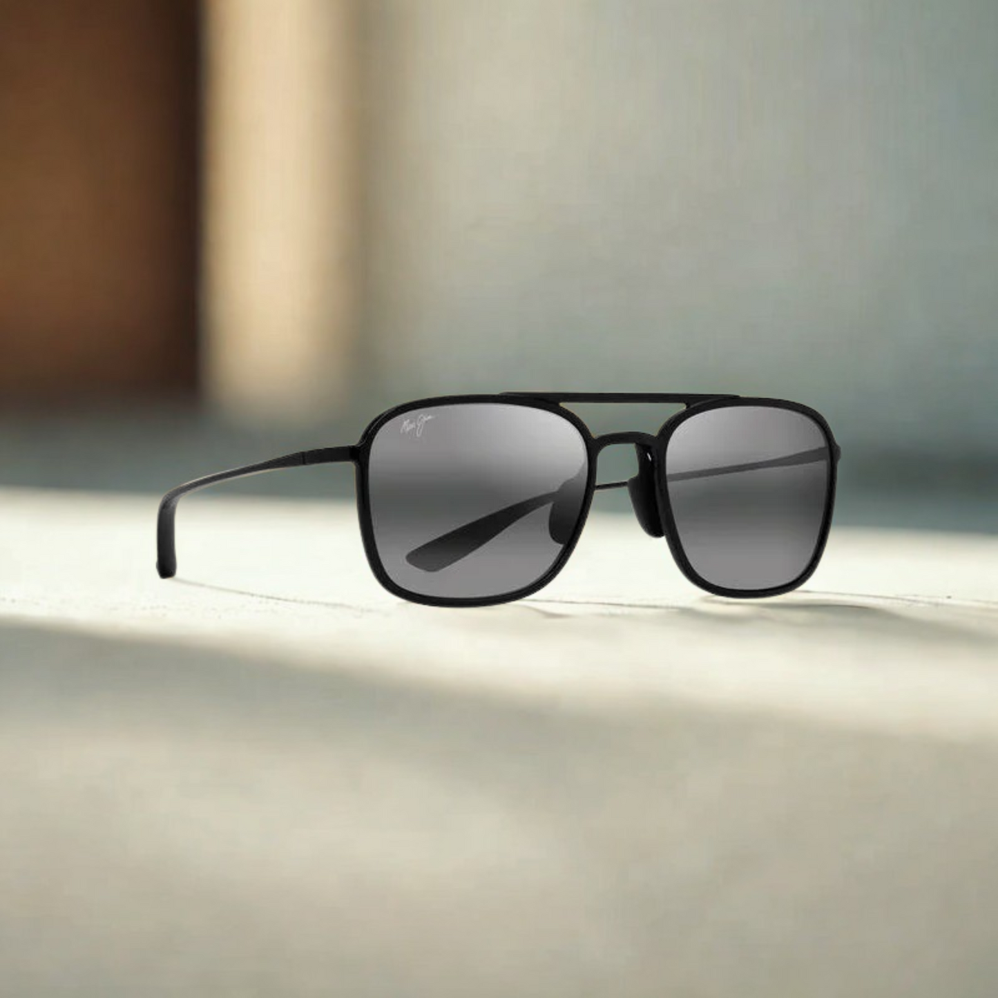Vista lateral de las gafas Maui Jim Keokea con fondo con montura de nailon ultraligero, lentes polarizadas grises o cálidas, estilo clásico-moderno, óptica en Calvià, Mallorca