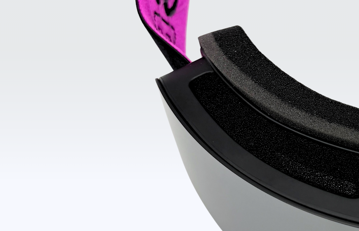Detalle de la máscara MOS Aitana Allblack: borde de la montura negra, espuma interior negra y lente espejo plateada