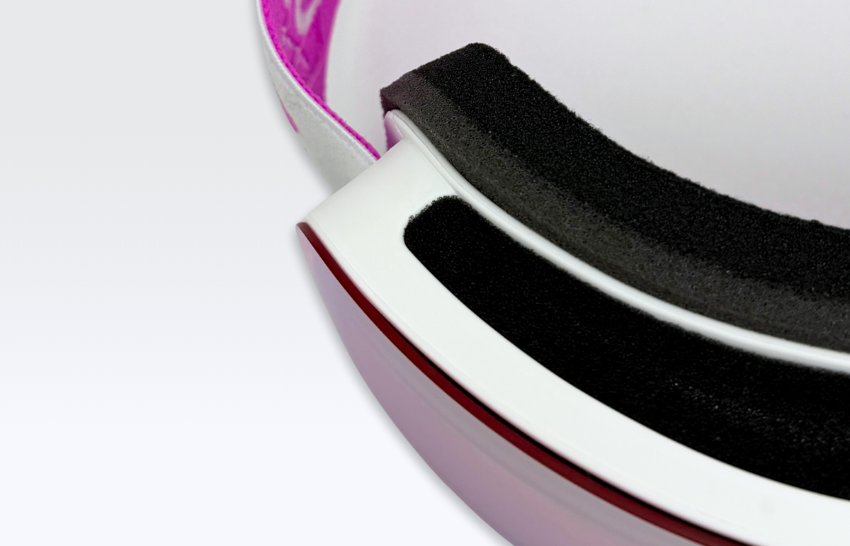 Detalle de la máscara MOS Aitana Pink: montura blanca, espuma interior negra y filo rojo de la lente espejo