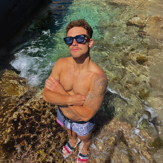 Persona usando gafas Gazelle BeneTTII negras con lentes azules, estilo urbano y alternativo en Mallorca